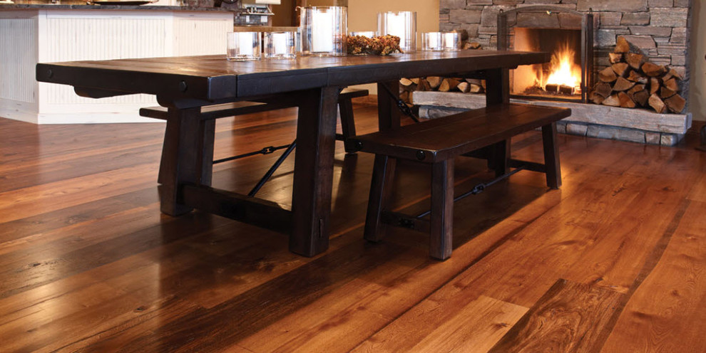Kitchen/dining room combo - large rustic medium tone wood floor kitchen/dining room combo idea with beige walls, a standard fireplace and a stone fireplace