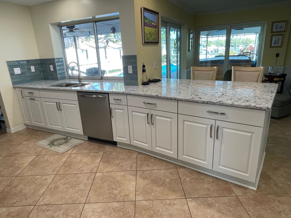Mid-sized transitional eat-in kitchen in Tampa with shaker cabinets, white cabinets, quartz benchtops, blue splashback and ceramic splashback.
