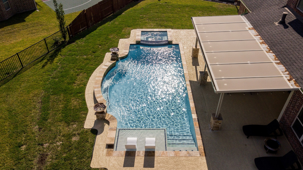 На фото: большой прямоугольный бассейн на заднем дворе в классическом стиле с настилом