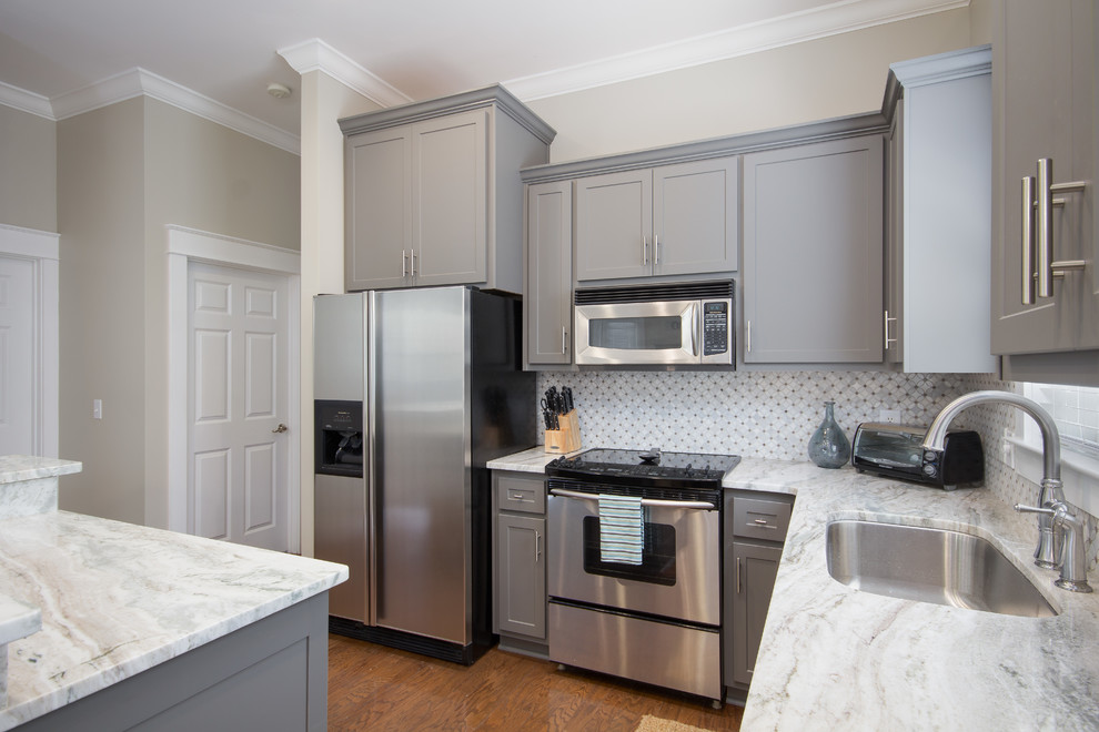 Mid-sized transitional l-shaped eat-in kitchen photo in Miami with an undermount sink, shaker cabinets, gray cabinets, stainless steel appliances and an island