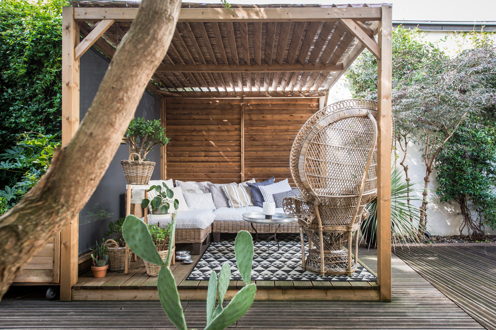 Design ideas for a tropical deck in Paris with a pergola.