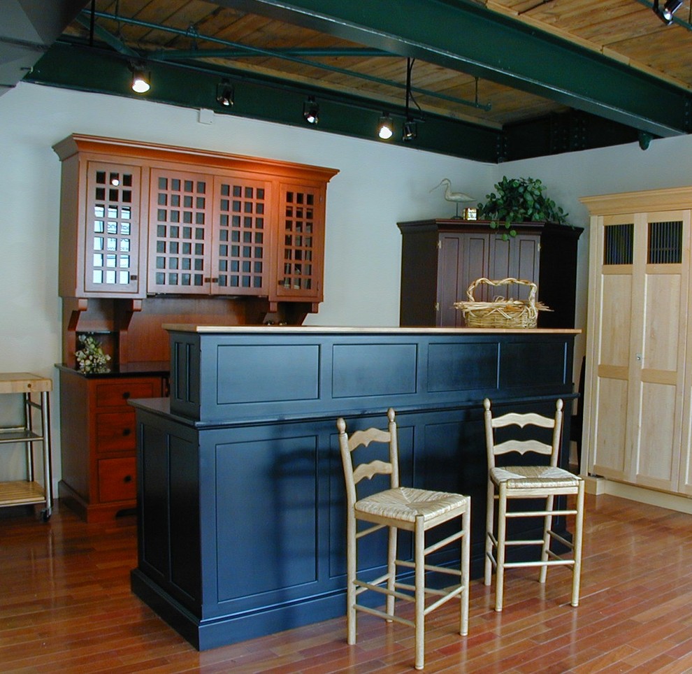This is an example of a small traditional galley home bar in Philadelphia with glass-front cabinets, medium wood cabinets, granite benchtops and medium hardwood floors.