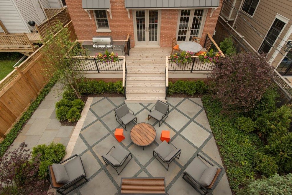 Mid-sized transitional backyard patio in Chicago with natural stone pavers.