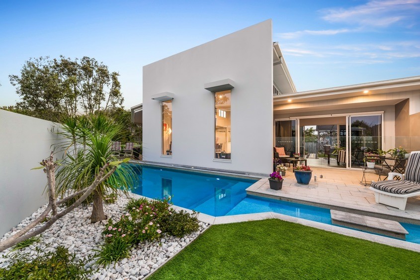 Photo of a mid-sized beach style courtyard custom-shaped natural pool in Sunshine Coast with a water feature and concrete pavers.