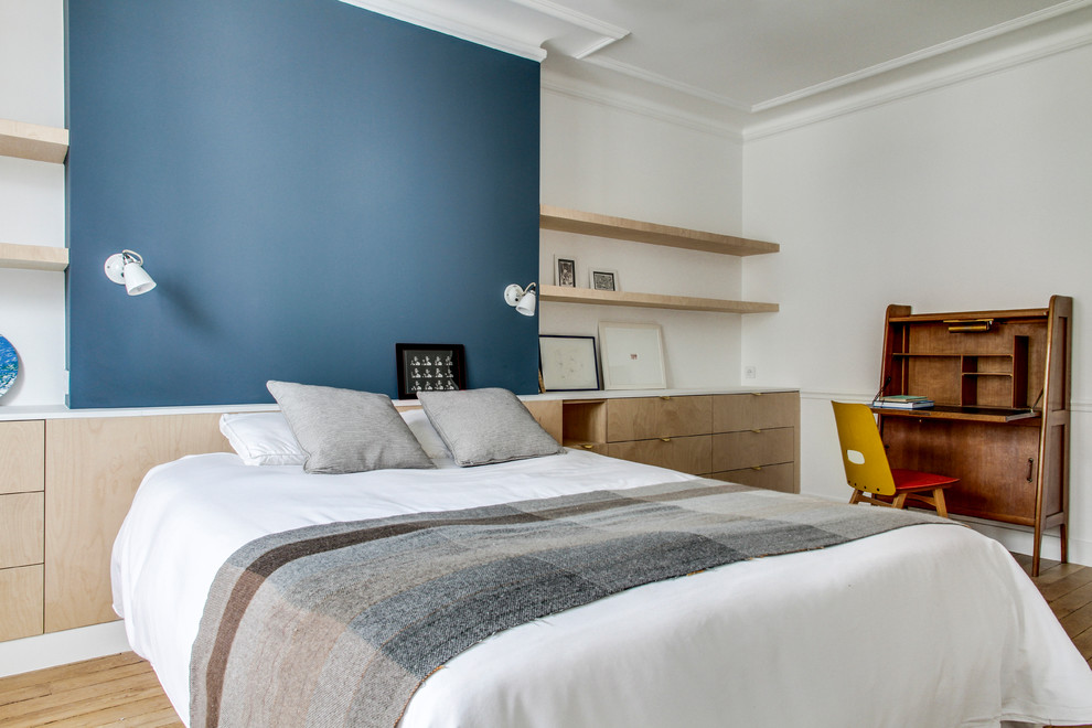 Scandinavian guest bedroom in Paris with white walls, light hardwood floors and beige floor.