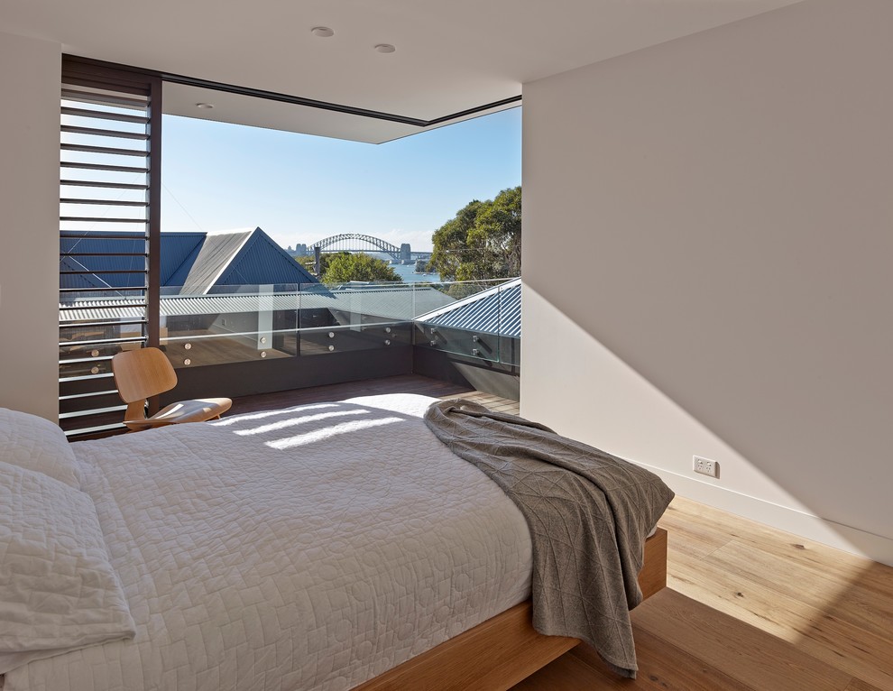 Design ideas for a modern bedroom in Sydney with white walls and light hardwood floors.