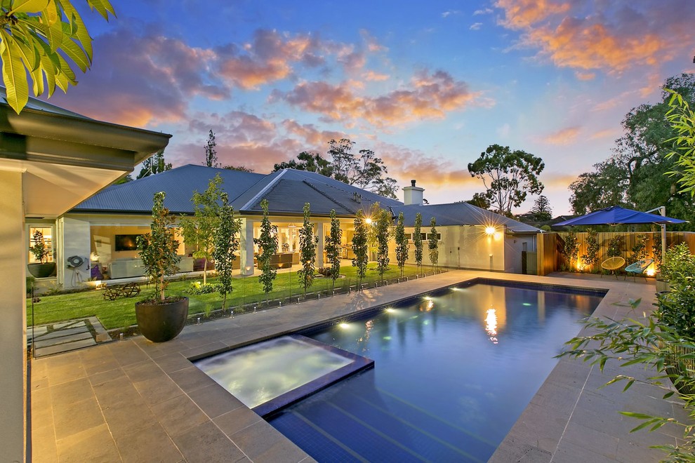 Inspiration for a mid-sized contemporary backyard rectangular pool in Adelaide with a hot tub and natural stone pavers.