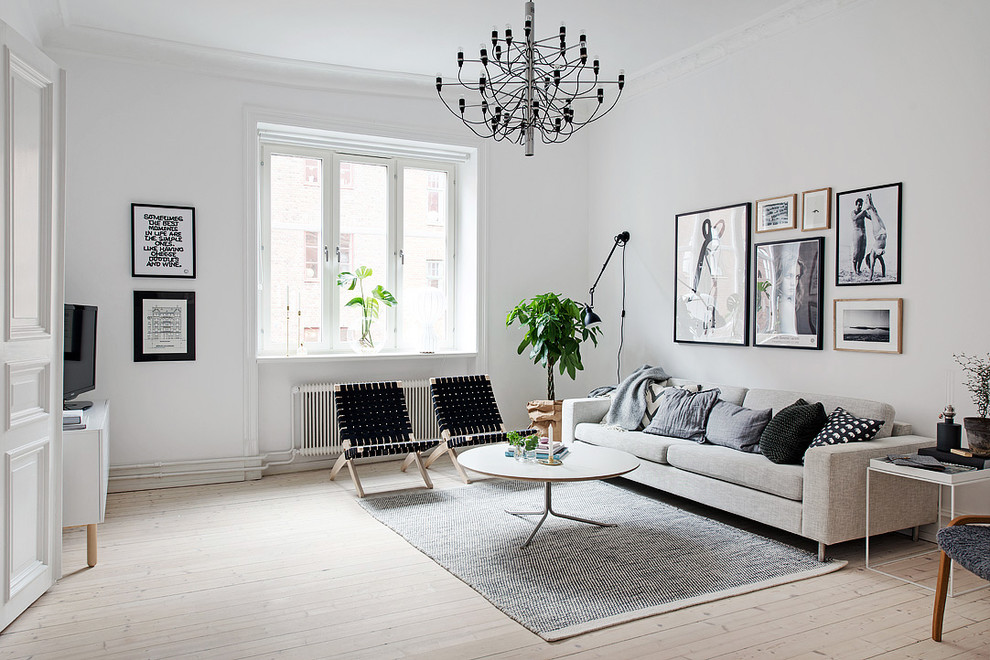 Mid-sized scandinavian formal enclosed living room in Gothenburg with white walls, light hardwood floors, no fireplace and no tv.