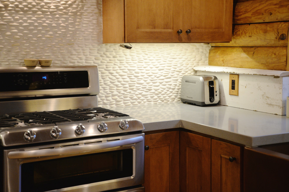 Mid-sized mountain style galley light wood floor open concept kitchen photo in Grand Rapids with an undermount sink, recessed-panel cabinets, medium tone wood cabinets, solid surface countertops, white backsplash, stainless steel appliances and an island