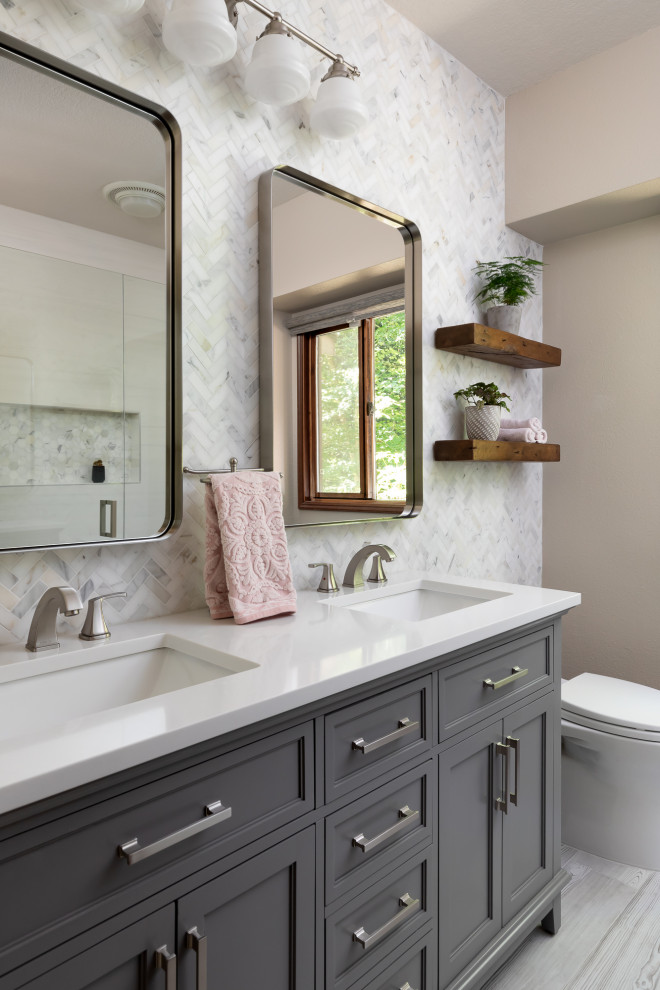 Inspiration for a transitional bathroom in Seattle with recessed-panel cabinets, grey cabinets, white tile, beige walls, wood-look tile, an undermount sink, grey floor, white benchtops, a double vanity, a freestanding vanity, an alcove shower, a one-piece toilet, engineered quartz benchtops, a hinged shower door and marble.