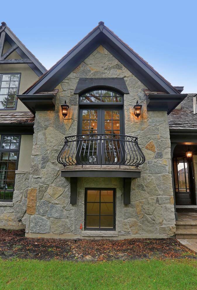 This is an example of a large traditional two-storey grey exterior in Chicago with stone veneer.