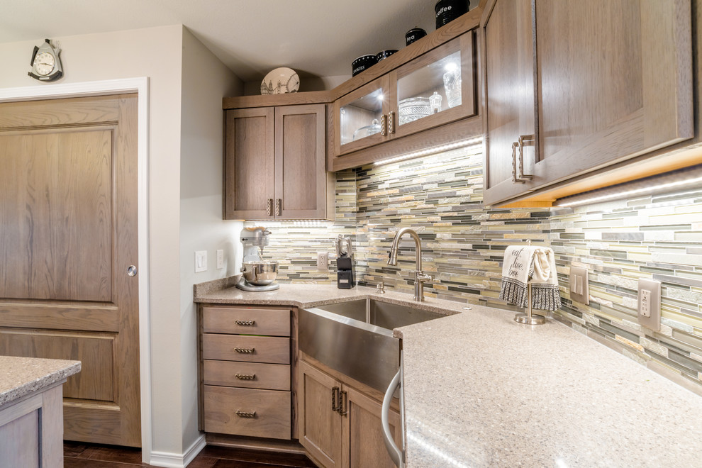 Mid-sized transitional u-shaped medium tone wood floor enclosed kitchen photo in Miami with a farmhouse sink, shaker cabinets, gray cabinets, quartz countertops, gray backsplash, glass tile backsplash, white appliances and an island