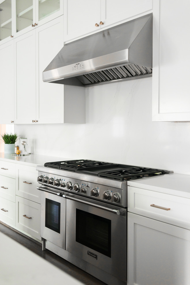 Open concept kitchen - transitional single-wall open concept kitchen idea in Houston with shaker cabinets, white cabinets, quartzite countertops, white backsplash, an island and white countertops