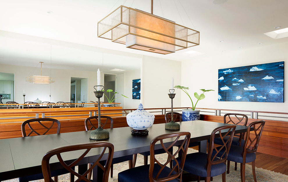 Transitional dining room in Hawaii with white walls and dark hardwood floors.