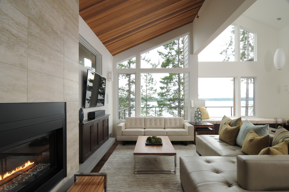 This is an example of a contemporary living room in Seattle with a ribbon fireplace, a metal fireplace surround and a wall-mounted tv.