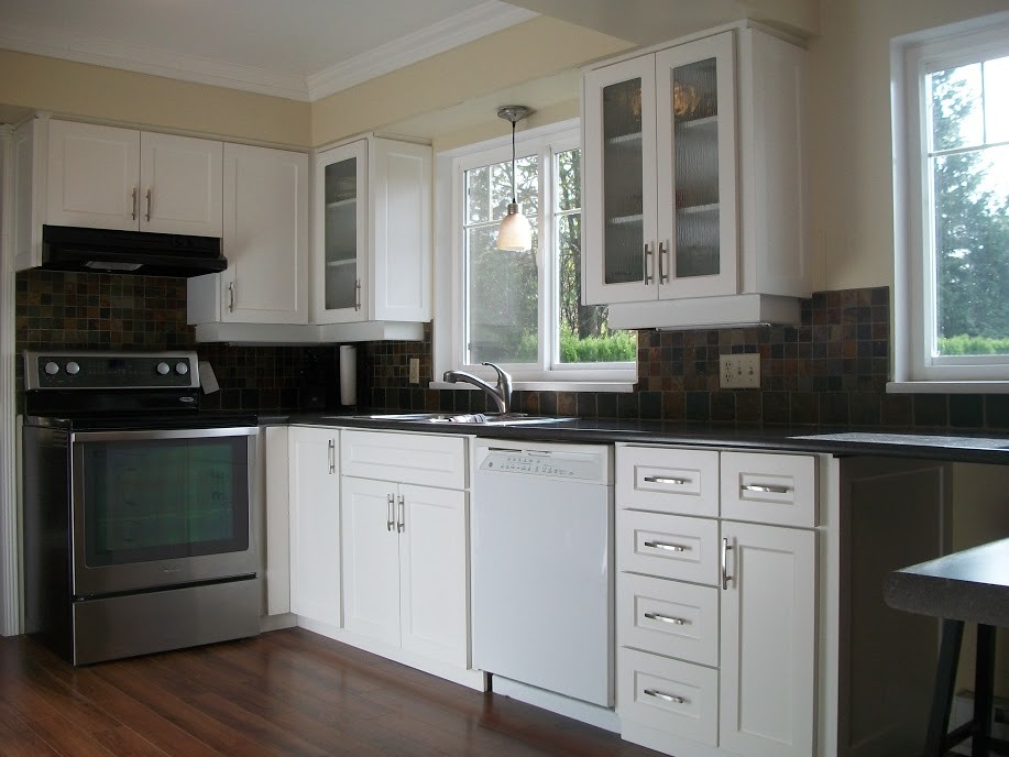 This is an example of a mid-sized transitional u-shaped eat-in kitchen in Vancouver with shaker cabinets and white cabinets.