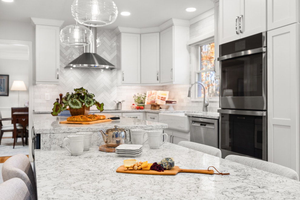 Inspiration for a mid-sized transitional kitchen remodel in DC Metro with shaker cabinets, white cabinets, quartz countertops, porcelain backsplash, stainless steel appliances and an island