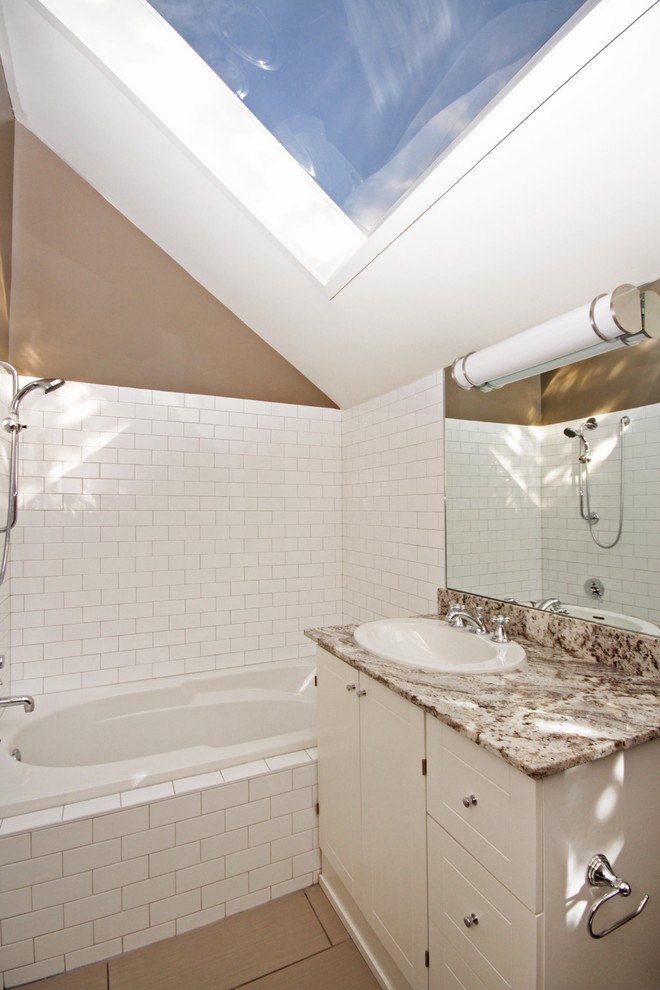 Inspiration for a large transitional 3/4 white tile ceramic tile drop-in bathtub remodel in Calgary with a drop-in sink, white cabinets, granite countertops and white walls
