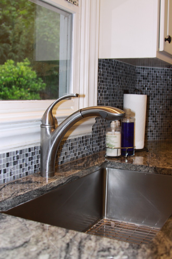Mid-sized transitional u-shaped light wood floor eat-in kitchen photo in Atlanta with an undermount sink, raised-panel cabinets, white cabinets, granite countertops, gray backsplash, mosaic tile backsplash, stainless steel appliances and an island