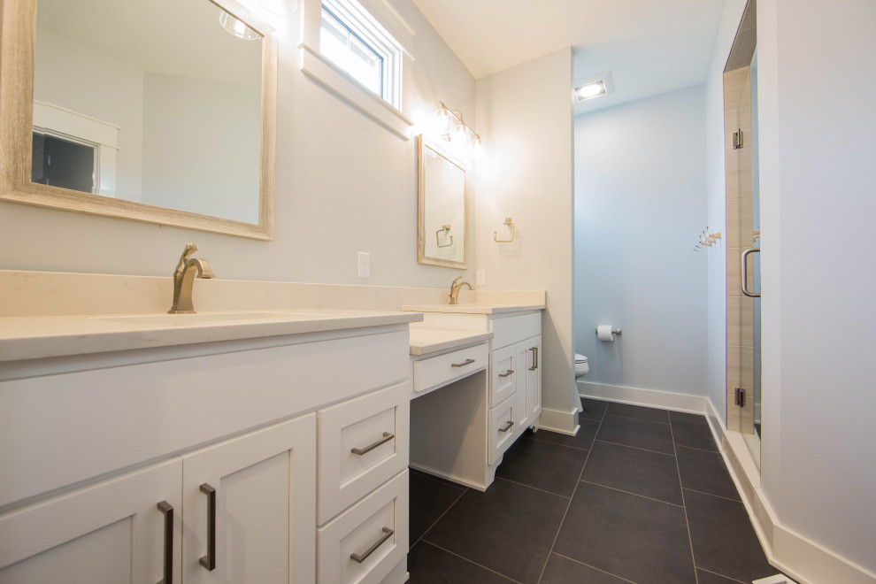 Exempel på ett mellanstort modernt beige beige en-suite badrum, med luckor med infälld panel, vita skåp, en dusch i en alkov, en toalettstol med separat cisternkåpa, grå väggar, klinkergolv i porslin, ett undermonterad handfat, granitbänkskiva, grått golv och dusch med gångjärnsdörr