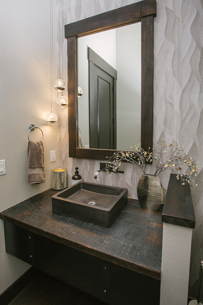 Inspiration for a mid-sized transitional powder room in Portland with dark wood cabinets, white walls, ceramic floors, an integrated sink, wood benchtops, brown floor, brown benchtops and a built-in vanity.