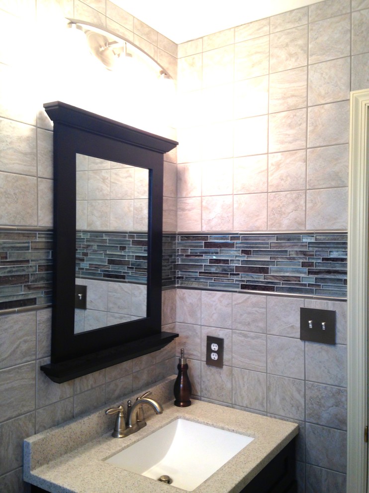 Inspiration for a small transitional 3/4 gray tile and porcelain tile ceramic tile alcove bathtub remodel with an integrated sink, recessed-panel cabinets, dark wood cabinets, solid surface countertops, a two-piece toilet and blue walls