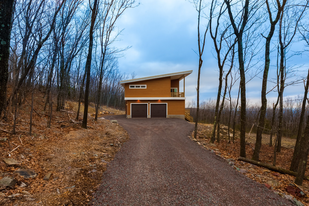 This is an example of a mid-sized contemporary two-storey orange house exterior in New York with a shed roof and wood siding.