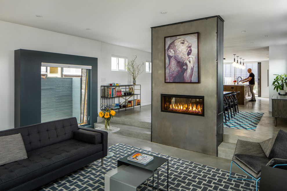 Mid-sized industrial open concept living room in Denver with white walls, concrete floors, a two-sided fireplace, a metal fireplace surround and grey floor.