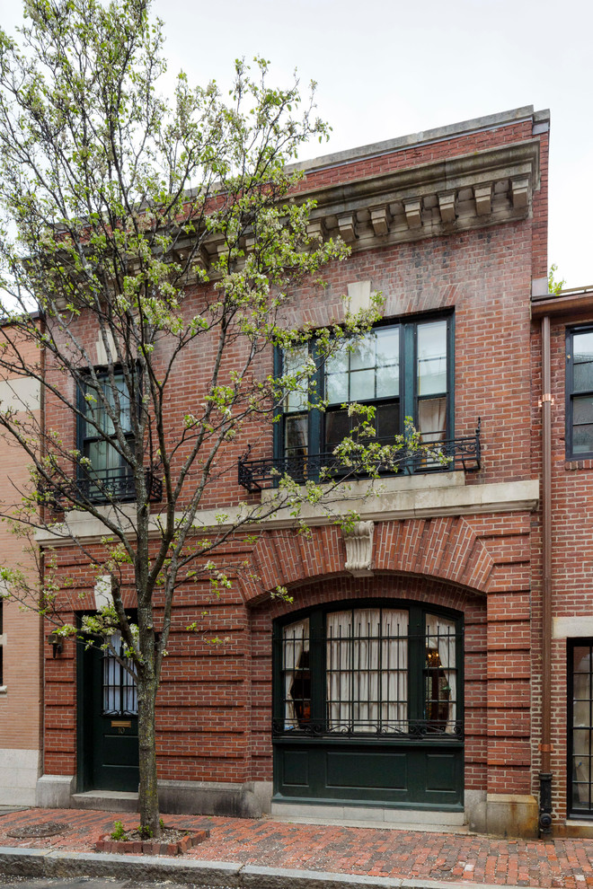 Photo of a mid-sized traditional two-storey brick red exterior in Boston with a flat roof.