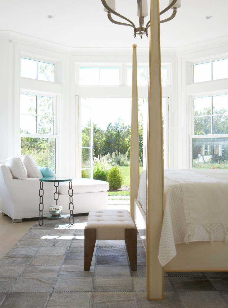This is an example of a large transitional master bedroom in New York with white walls.