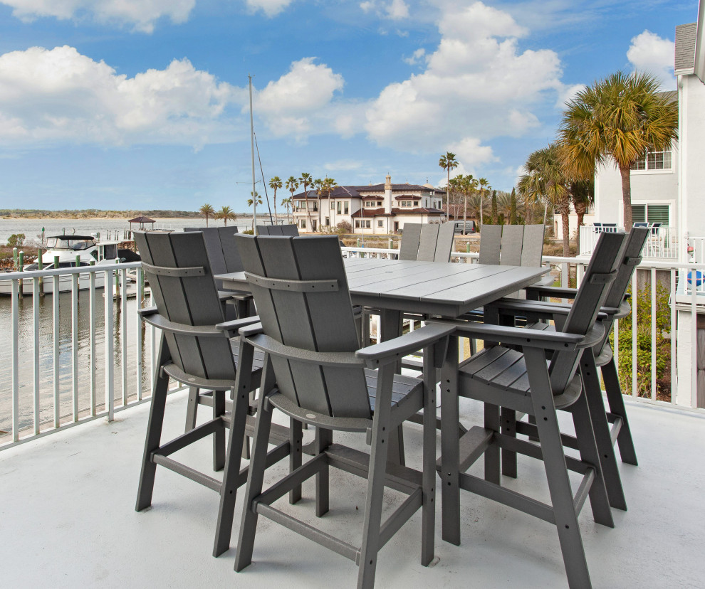 Mid-sized beach style first floor deck in Jacksonville with metal railing and no cover.