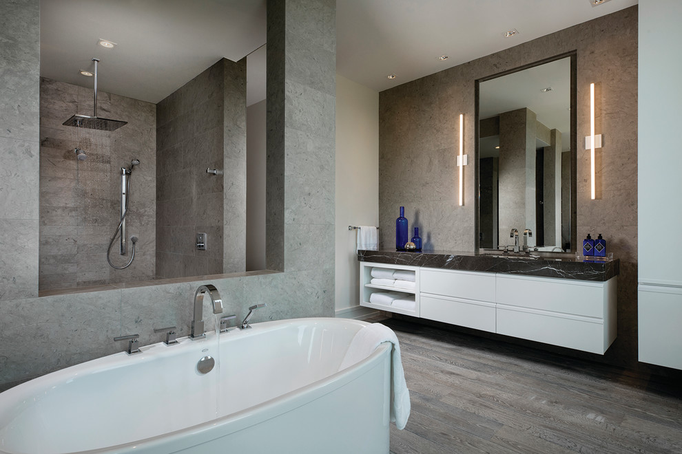 Design ideas for an expansive contemporary master bathroom in Other with flat-panel cabinets, white cabinets, a freestanding tub, an open shower, brown floor, gray tile and dark hardwood floors.