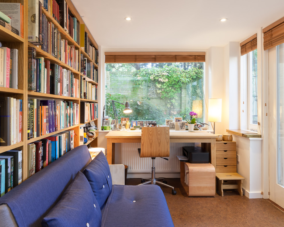 Small contemporary home office in London with a library, white walls and a freestanding desk.