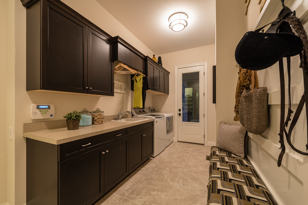 This is an example of a mid-sized transitional galley utility room in Cincinnati with a drop-in sink, flat-panel cabinets, dark wood cabinets, laminate benchtops, white walls, ceramic floors and a side-by-side washer and dryer.