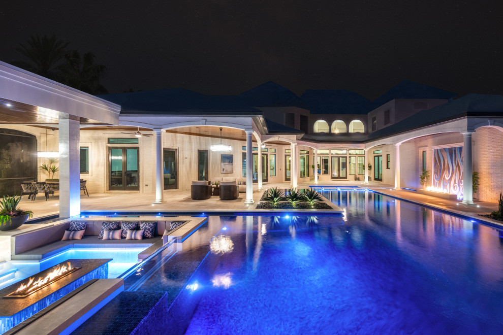 Idee per una grande piscina a sfioro infinito minimal personalizzata dietro casa con piastrelle