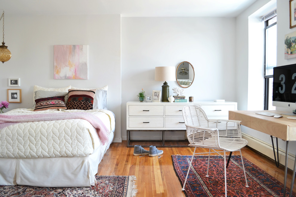 Design ideas for an eclectic bedroom in New York with white walls and medium hardwood floors.