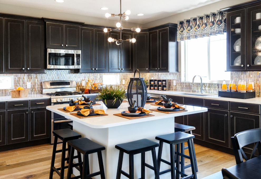 Photo of a large transitional l-shaped kitchen in Salt Lake City with an undermount sink, recessed-panel cabinets, black cabinets, beige splashback, stainless steel appliances and with island.