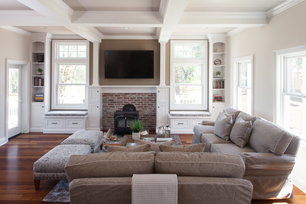Inspiration for a mid-sized traditional enclosed living room in Philadelphia with a wood stove, a brick fireplace surround, a wall-mounted tv, bamboo floors and grey walls.