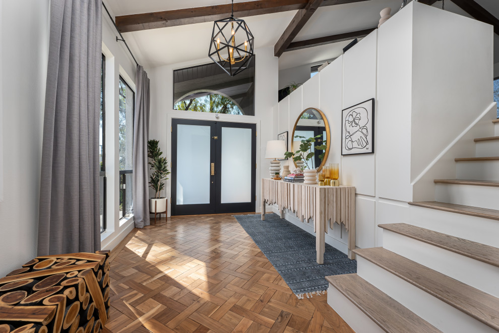 Mid-sized contemporary foyer in Los Angeles with white walls, medium hardwood floors, a double front door, a blue front door and exposed beam.