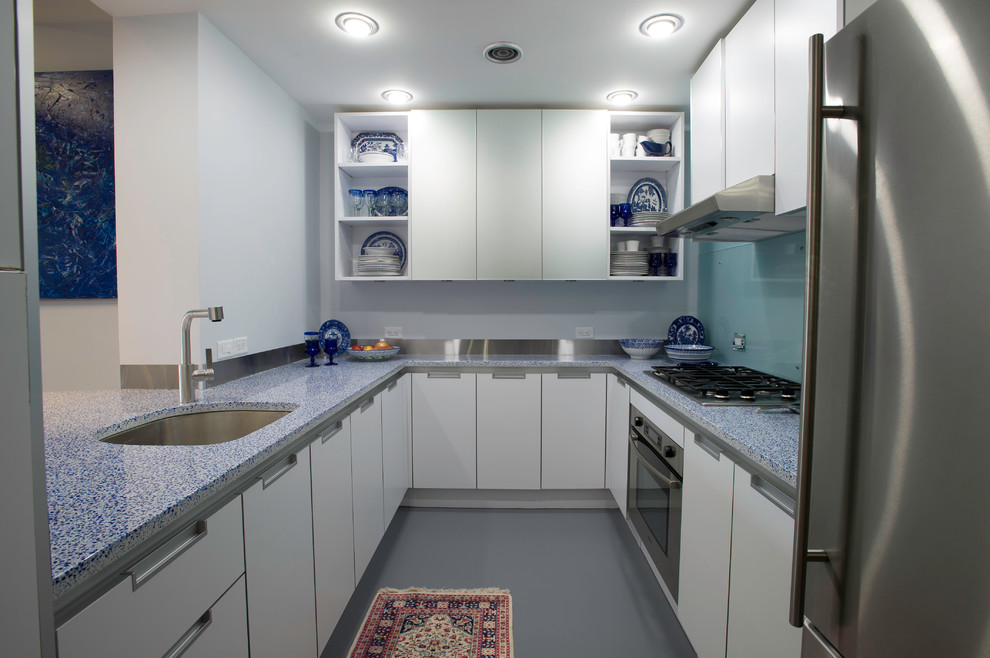 Photo of a small contemporary u-shaped separate kitchen in Boston with recessed-panel cabinets, white cabinets, blue splashback, glass sheet splashback, stainless steel appliances, linoleum floors, an undermount sink, quartz benchtops and a peninsula.
