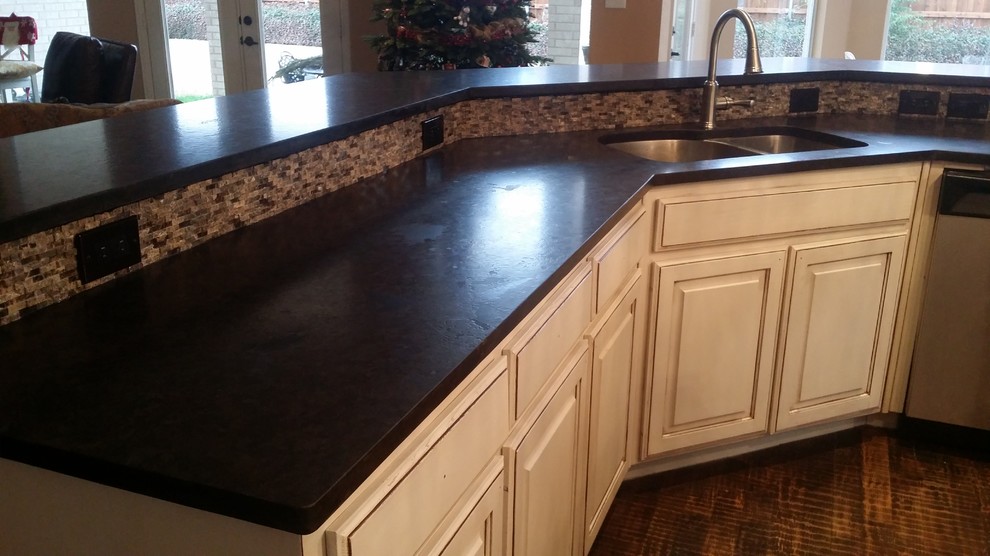 Inspiration for a large transitional brown floor open concept kitchen remodel in Dallas with an undermount sink, raised-panel cabinets, white cabinets, granite countertops, gray backsplash, stone tile backsplash, stainless steel appliances and an island