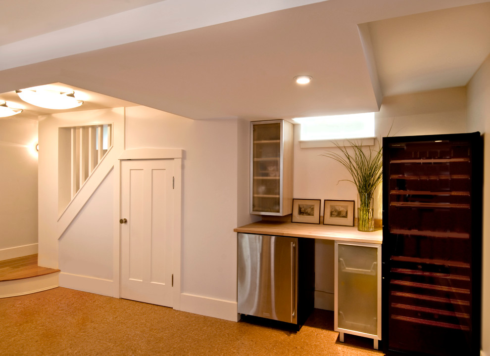 Photo of a contemporary look-out basement in Boston with white walls and cork floors.