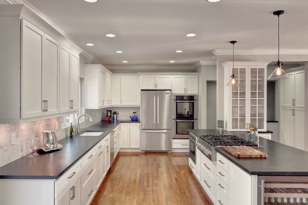 Design ideas for a traditional u-shaped eat-in kitchen in San Diego with a drop-in sink, glass-front cabinets, white cabinets, granite benchtops, grey splashback, subway tile splashback and stainless steel appliances.