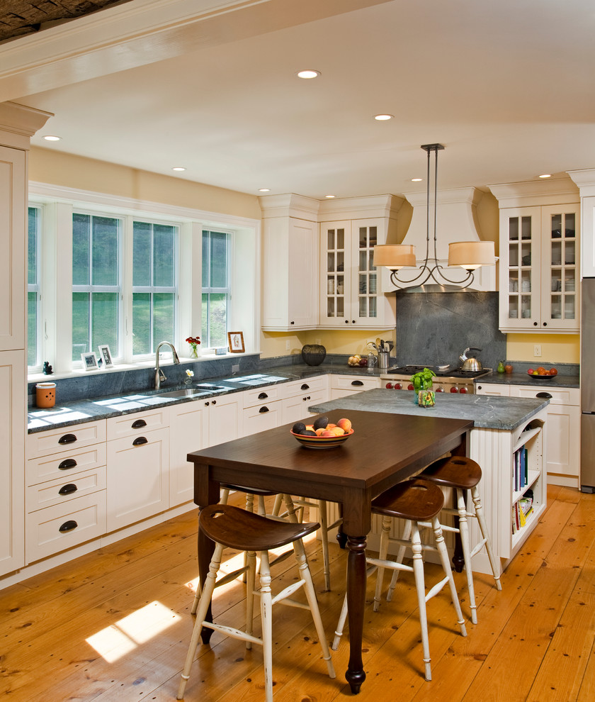 Photo of a country u-shaped eat-in kitchen in Philadelphia with an undermount sink, shaker cabinets, white cabinets, grey splashback and stainless steel appliances.