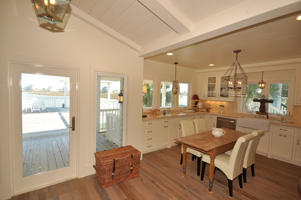 Inspiration for a beach style u-shaped eat-in kitchen in Houston with a farmhouse sink, white cabinets, marble benchtops and light hardwood floors.