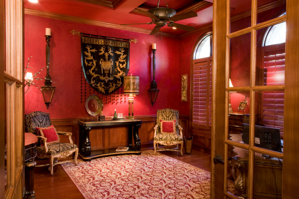 Mid-sized traditional study room in Charleston with red walls, dark hardwood floors, no fireplace and a freestanding desk.