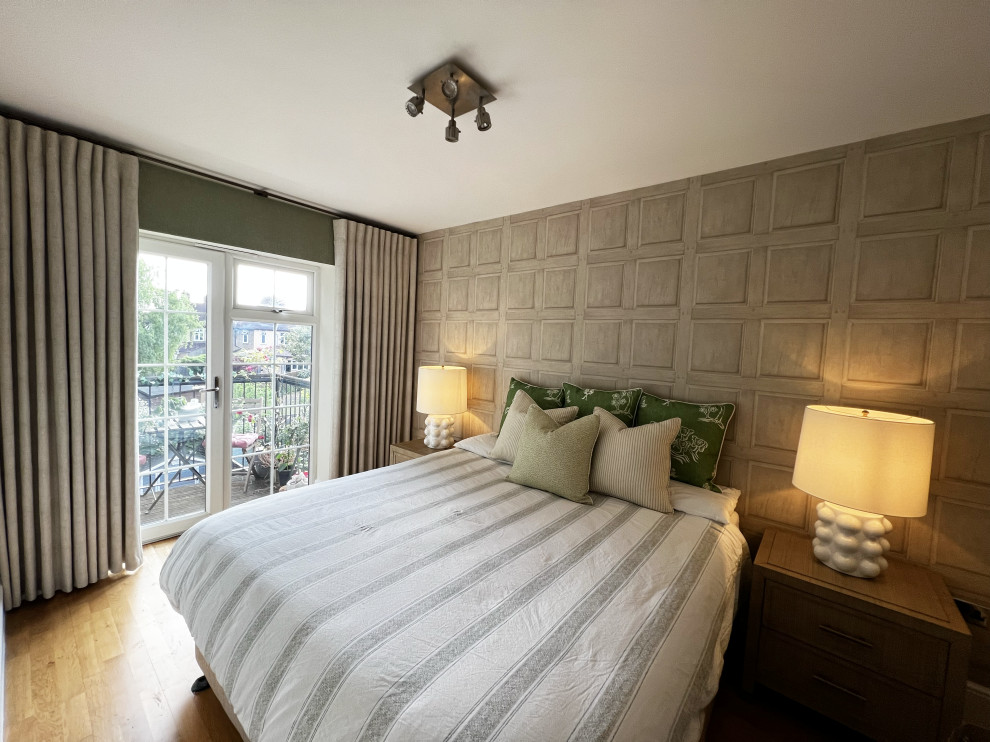 Design ideas for a mid-sized contemporary master bedroom in London with beige walls, medium hardwood floors and wallpaper.