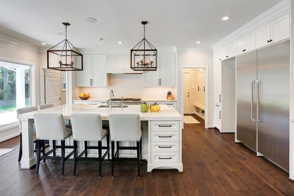 This is an example of a large modern l-shaped eat-in kitchen in Houston with a drop-in sink, shaker cabinets, white cabinets, granite benchtops, white splashback, ceramic splashback, stainless steel appliances, medium hardwood floors and with island.