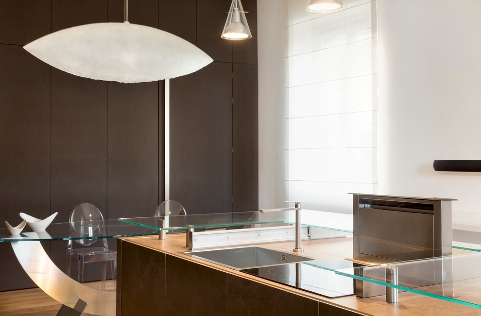 Photo of a contemporary single-wall eat-in kitchen in Turin with a single-bowl sink, flat-panel cabinets, brown cabinets, tile benchtops, brown splashback, glass sheet splashback, stainless steel appliances, ceramic floors and with island.