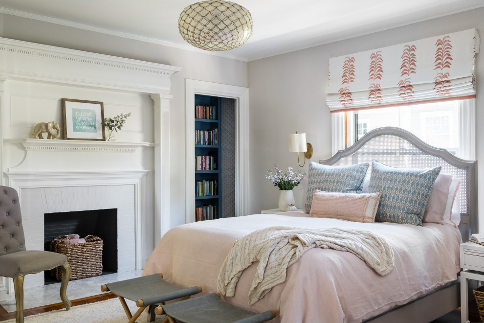 Design ideas for a transitional bedroom in Boston with grey walls, medium hardwood floors, a standard fireplace and brown floor.
